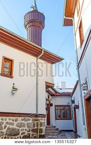 The new wooden minaret rises over the white cottages in the restored neighborhood of the Turkish village Ankara Turkey.