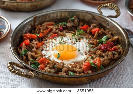 Fried egg with mince meat in traditional turkish pan close view