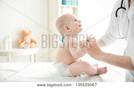 Doctor doing exercises with baby