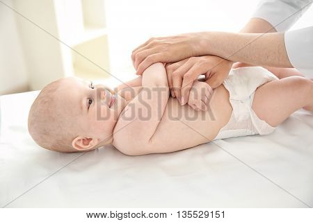 Doctor doing exercises with baby