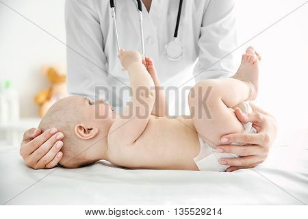 Doctor doing exercises with baby