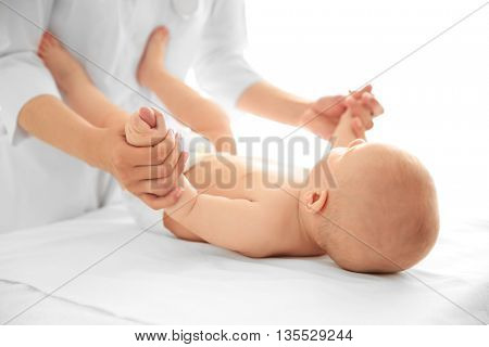 Doctor doing exercises with baby