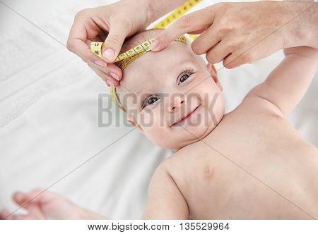 Professional pediatrician examining smiling baby