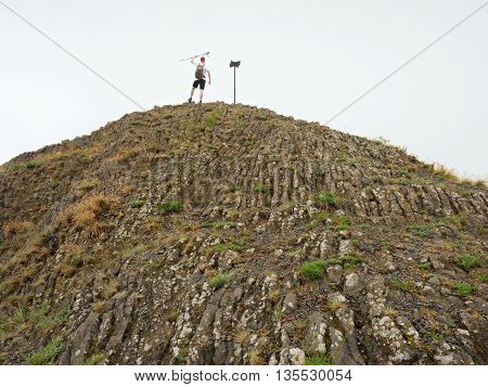 Tourist On Sharp Basalt  Peak Of Volcano  Formation