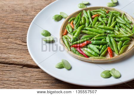 Little Thai chili spicy and Parkia speciosa sator bean on Basketry white plate ingredient for Thai Food cuisine