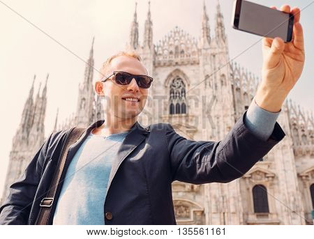 Man take a selfie photo on Duomo di Milano background