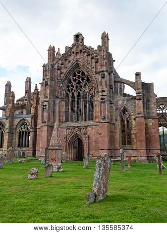 The ruins of pink colored Melrose Abbey in the Scottisch Borders region in Scotland
