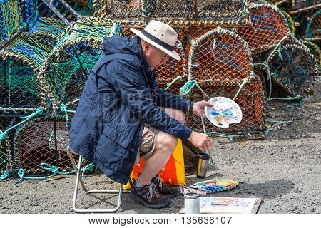 Crail Scotland - July 26 2012: Fife area a painter in the harbor.
