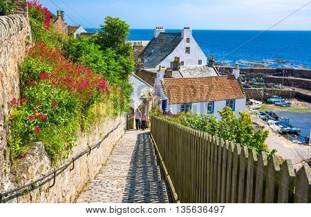 Crail Scotland - July 26 2012: Fife area people between traditional houses on the harbor.