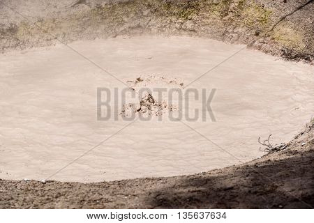 Yellowstone United States - May 31 2015: Mudpot in Yellowstone National Park steam and limy shoreline people on boardwalk West Thumb area of Yellowstone National Park Wyoming.