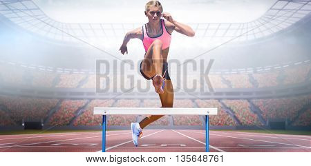 Athletic woman practicing show jumping against view of a stadium