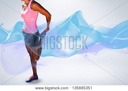 Sporty woman stretching her leg against grey background