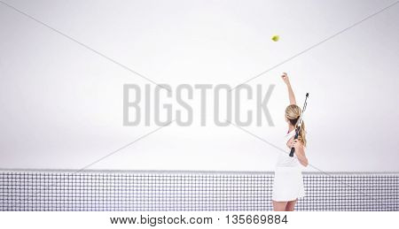 Athlete holding a tennis racquet ready to serve against grey background