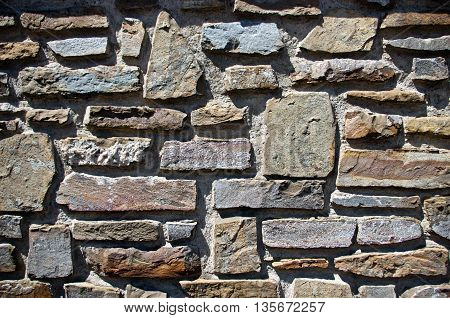 wall of stones of different colors aligned in a non-formal