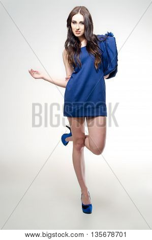 young attractive girk wear blue dress and shoes, posing in studio