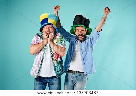 The two football fans with different emotions over blue background