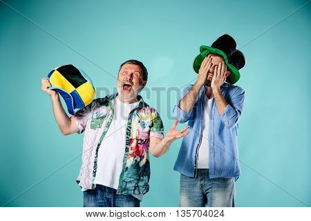 The two football fans with different emotions over blue background