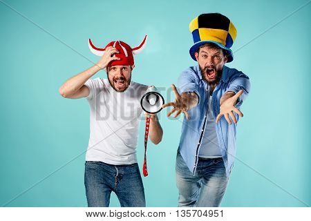 The two football fans with mouthpiece over blue background