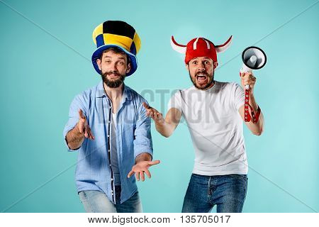 The two football fans with mouthpiece over blue background
