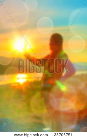Abstract Blurred and soft photo of Women on hilltop with bokeh of sunrise on the natural background