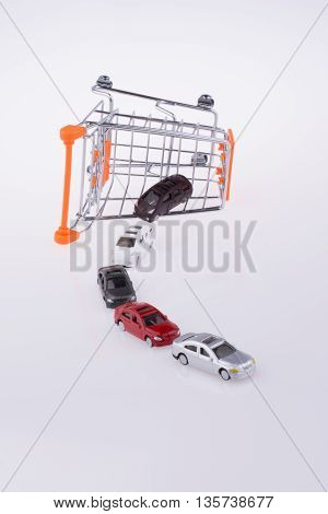 Cars coming out of a shopping cart on white background