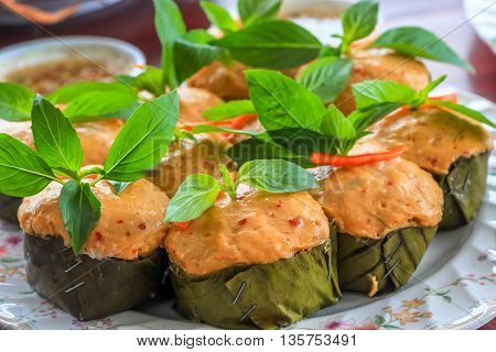 Thai steamed curry fish in banana leaf cups decorated with basil leaf (Hor Mok Pla)
