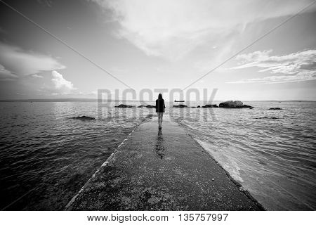 Woman doing yoga at the dock.Mindfulness state.Woman relaxing at the seaside dock in tree pose.