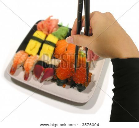 Fotografie ženy jíst sushi pomocí hůlky