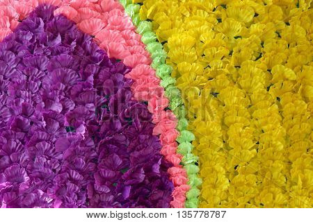 Background of colorful fake flowers that decorated the backdrop for the design of nature.