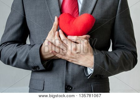 Businessman Showing Compassion Holding Red Heart Onto His Chest In His Suit - Crm, Service Mind Busi