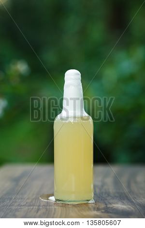 homemade lemonade in glass bottle on bokeh background. Lemon beer.