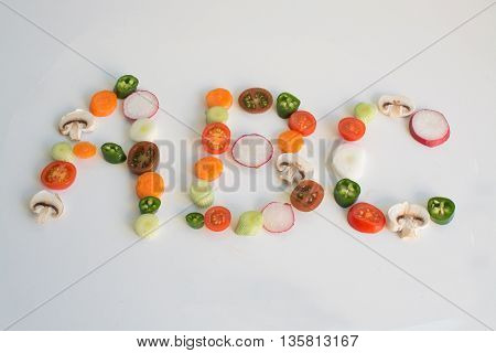 ABC spelled out from vegetable slices on a white background