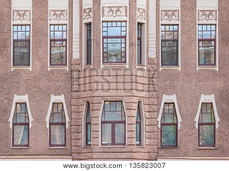 Several windows in a row and bay window on facade of urban apartment building front view St. Petersburg Russia