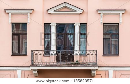 Several windows in a row and balcony on facade of urban apartment building front view St. Petersburg Russia