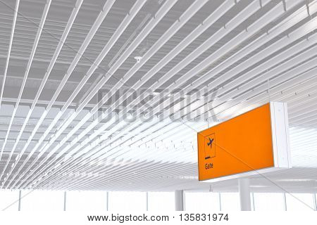 Yellow illuminated sign at airport with gate number for departing flights