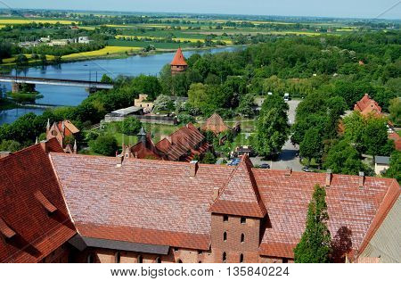 Malbork Poland -May 29 2010: High Castle at 14th-15th century Malbork Castle once the domain of the Teutonic Knights and Europe's largest medieval castle situated next to the River Nogat and nearby fields of yellow Rapeseed flowers