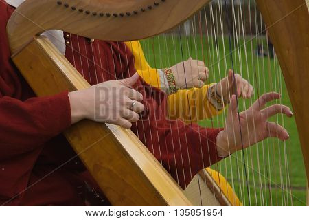 Two harps. Harp strings close up hands