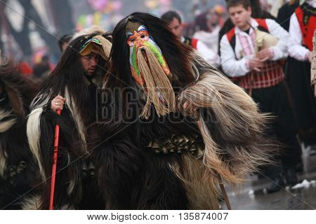 Pernik, Bulgaria - January30, 2010: Unidentified man in traditional Kukeri costume are seen at the Festival of the Masquerade Games Surva in Pernik, Bulgaria.