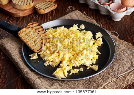 Homemade rustic breakfast Scrambled eggs on Pan with grilled toast