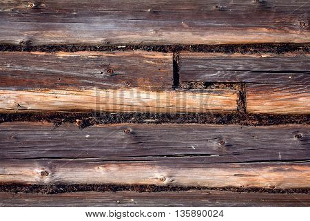 The wall made of wooden logs. The joint between the logs. Background