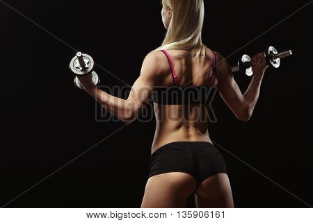 Sexy fitness ass close-up. Part of fitness body on a black background. Perfect female sports figure. Fitness woman posing in the studio. Fitness photo shoot in the studio. Fitness bikini