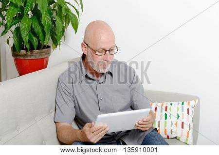 a mature man at home websurfing on internet