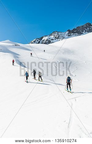 Skiers ascending a mountain slope. Ski touring in Malta valley, Austria.