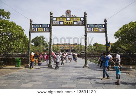 Hue, Vietnam - Jun 16, 2016: Visitors coming to see the Imperial Royal Palace of Nguyen dynasty at Ngo Mon gate. This gate is one of the forbidden city main gates.
