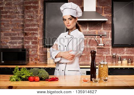 Woman Cook Standing In The Kitchen In White Cook Uniform.
