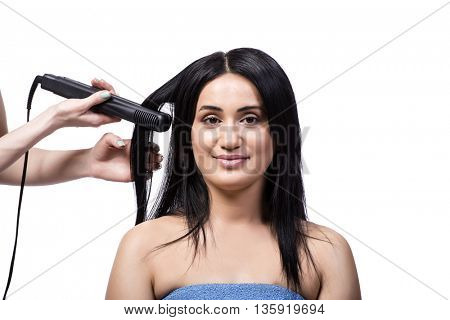 Young woman getting hair straightner isolated on white