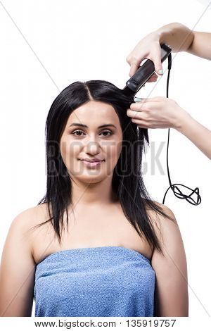 Young woman getting hair straightner isolated on white