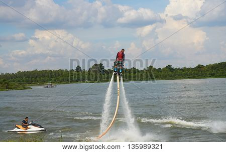 MUSEUM SERPENT KARK, YASOTHON, THAILAND - JUNE 19, 2016: Man ride on flyboard; an extreme water sport at public park.