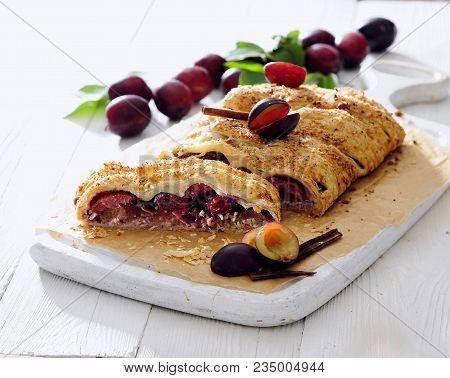 Fresh Plum And Ricotta Strudel Sprinkled With Brown Sugar And Cinnamon.