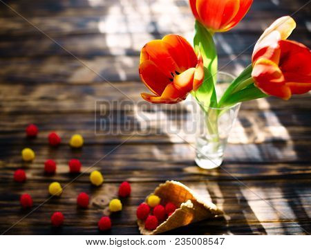 Blossoming Red Tulips On A Wooden Background With Sweets